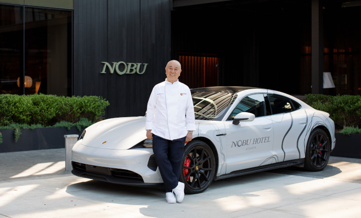 Chef Nobu in front of a Porsche