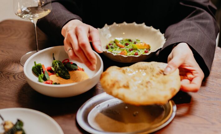 ‘family style’ geserveerde dips en gerechten met pita uit de steenoven bij Ora Taverna & Bar - credits Fleur Fotografeert